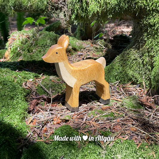 Handgefertigtes Holzspielzeug Reh Ricke von Allgäuer Holztiere, braun und schwarz bemalt mit pflanzlichen Farben, stehend auf Waldboden und Moos in natürlicher Umgebung, aus bayerischem Ahornholz gefertigt, nachhaltig produziert im Allgäu und für Kinder ab 3 Jahren geeignet.