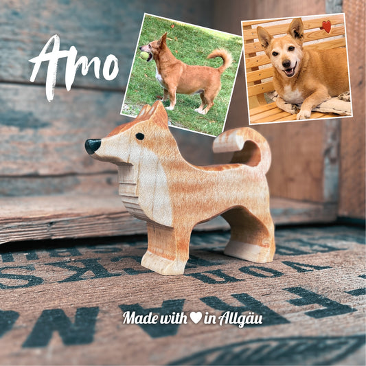 Handgefertigters Holzspielzeug Hund Rüde Amo von Allgäuer Holztiere, hellbraun bemalt mit pflanzlichen Farben, stehend in natürlicher Umgebung, aus bayerischem Ahornholz gefertigt, nachhaltig produziert im Allgäu und für Kinder ab 3 Jahren geeignet.