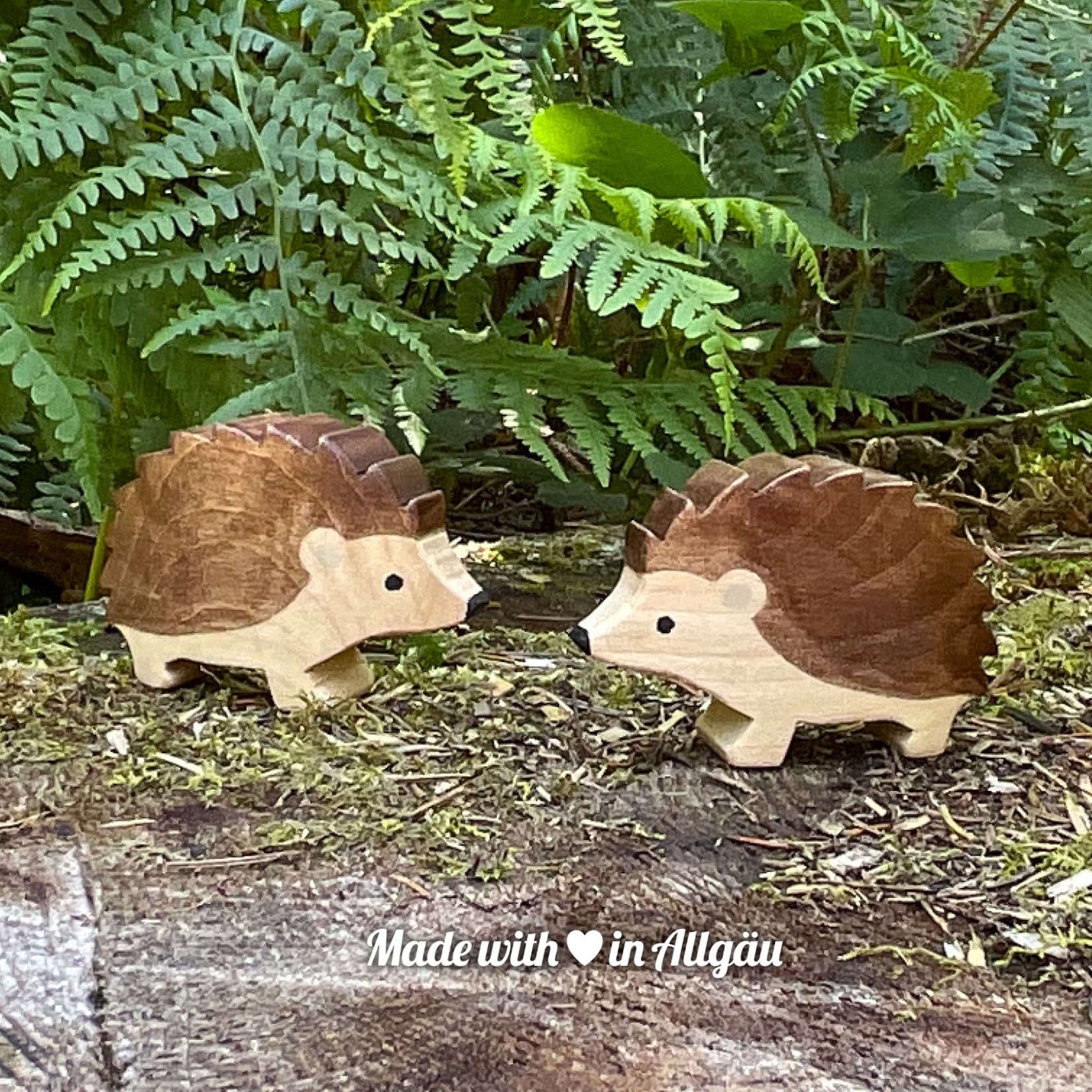 Handgefertigtes Holzspielzeug Igel Weibchen von Allgäuer Holztiere, braun bemalt mit pflanzlichen Farben, stehend auf Waldboden in natürlicher Umgebung, aus bayerischem Ahornholz gefertigt, nachhaltig produziert im Allgäu und für Kinder ab 3 Jahren geeignet.