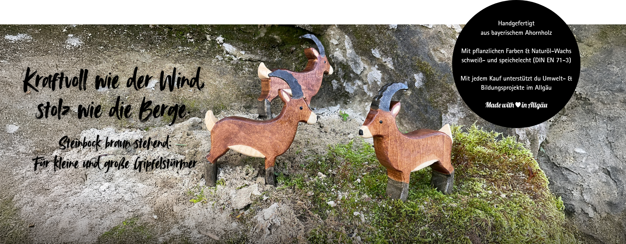 Jetzt entdecken: handgefertigtes Holzspielzeug Steinbock von Allgäuer Holztiere, aus bayerischem Ahornholz gefertigt, bemalt mit pflanzlichen Farben und mit Naturöl-Wachs geschützt. Drei braun schwarze Steinböcke stehen auf Moos und Felsen in Alpen Landschaft, nachhaltig produziert im Allgäu, Made with Love in Allgäu.